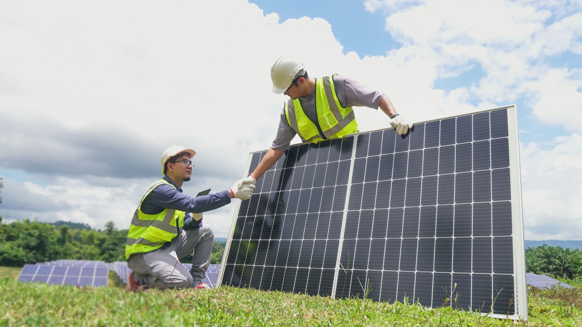 Two asian engineers shaking hands after  installing solar panels . Solar energy clean and green alternative energy. Unity and teamwork.