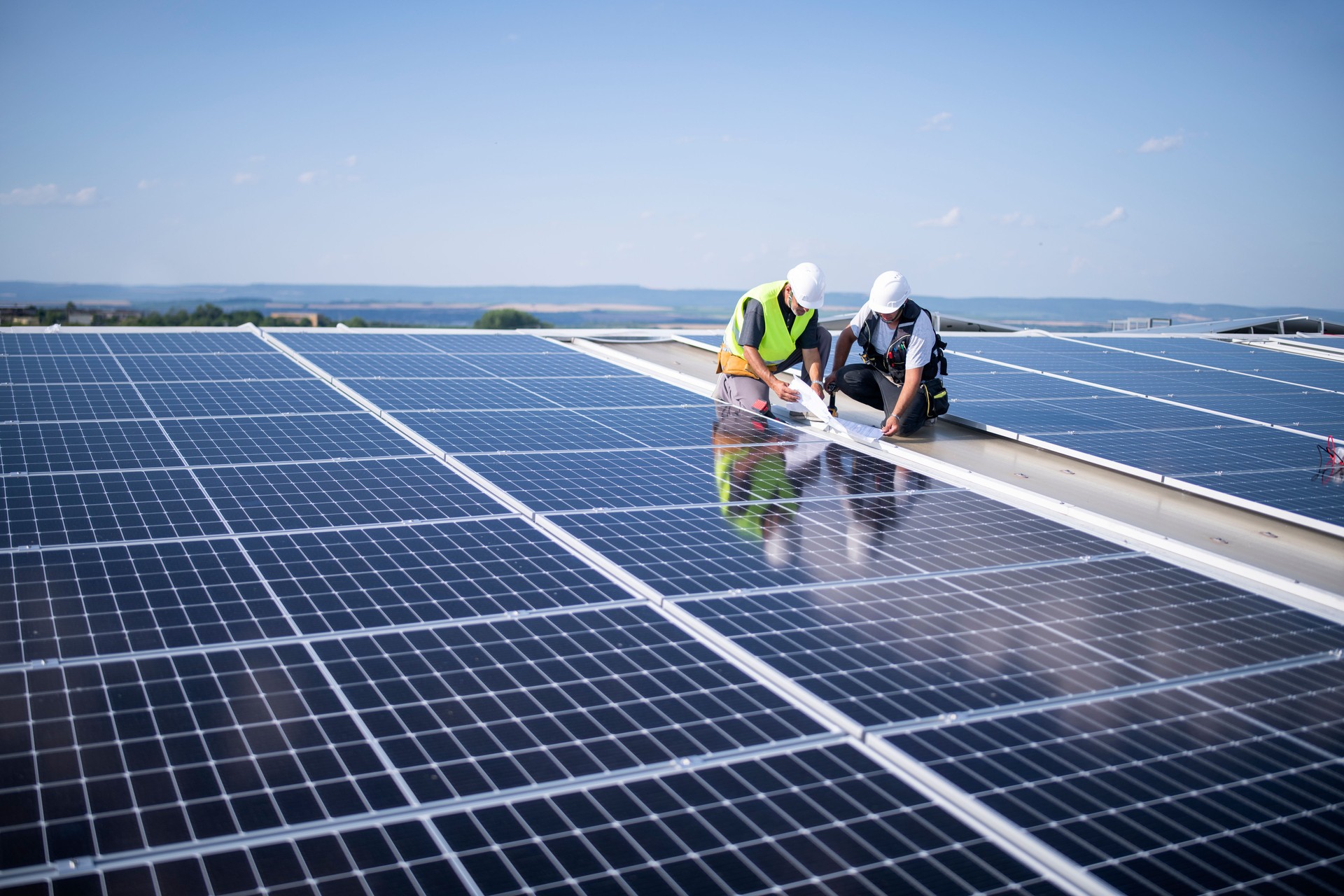 Team of electrical engineers installing solar panels.